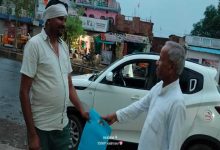 बाजार में लोगों को कपड़े का थैला देते गंगाराम पटेल।