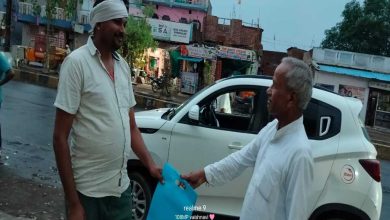 बाजार में लोगों को कपड़े का थैला देते गंगाराम पटेल।