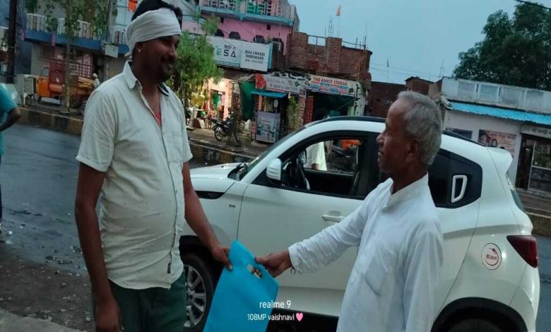 बाजार में लोगों को कपड़े का थैला देते गंगाराम पटेल।