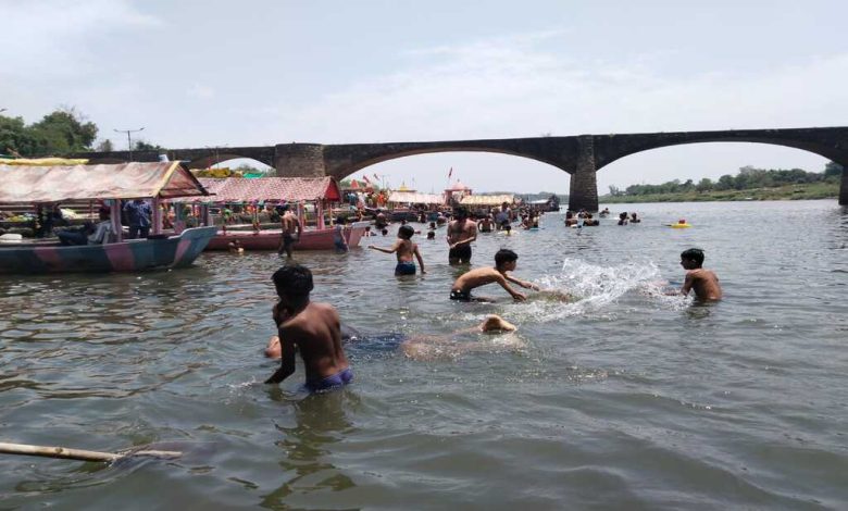 गर्मी से बचने लोग नर्मदा नदी के घाटों में पहुंच रहे हैं।
